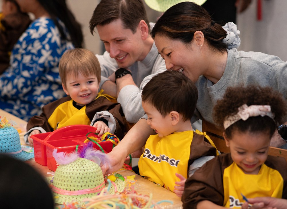 Families making decorated hats together