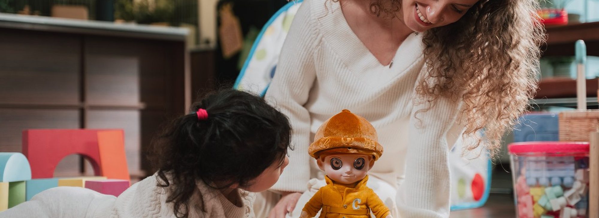 A child and her mum playing with CURI on the floor